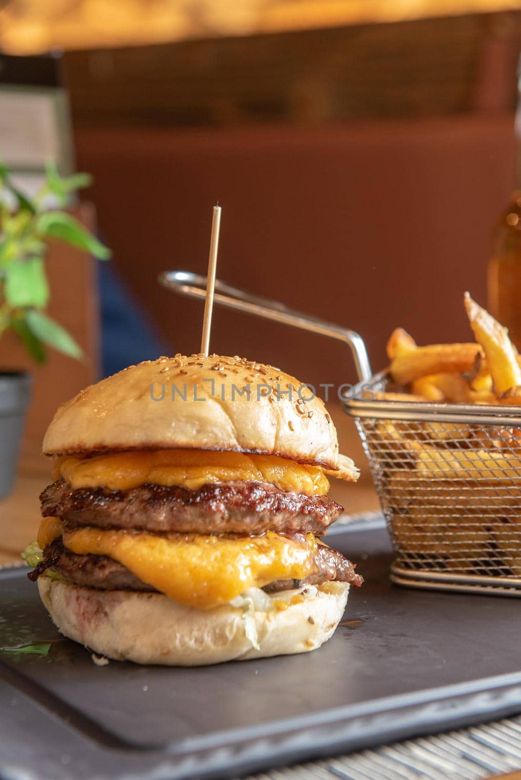 Homemade hamburger with french fries on black stone flat.