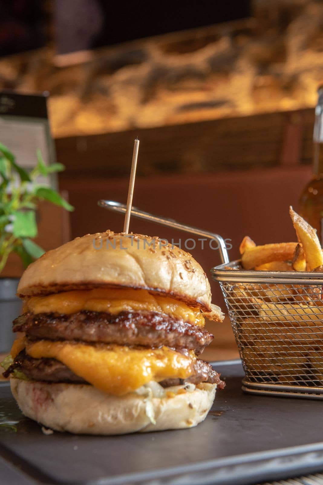 Homemade hamburger with french fries on black stone flat.