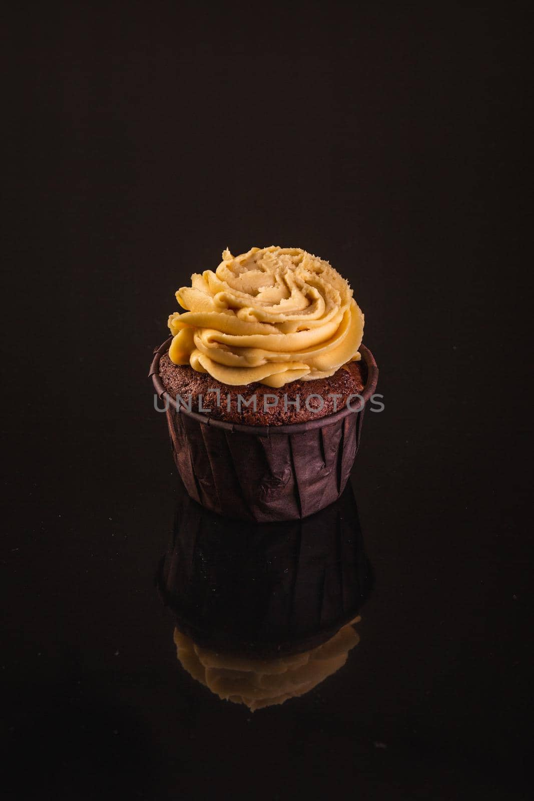 Peanut Butter Cupcake On A Black Background With Reflection.