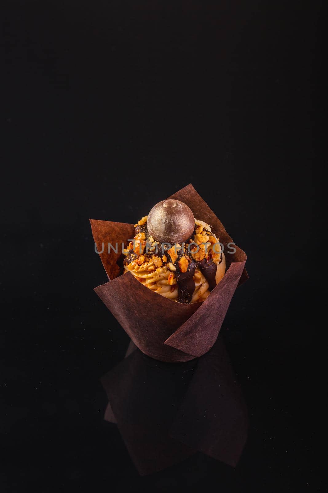 Peanut Butter Cupcake On A Black Background With Reflection.