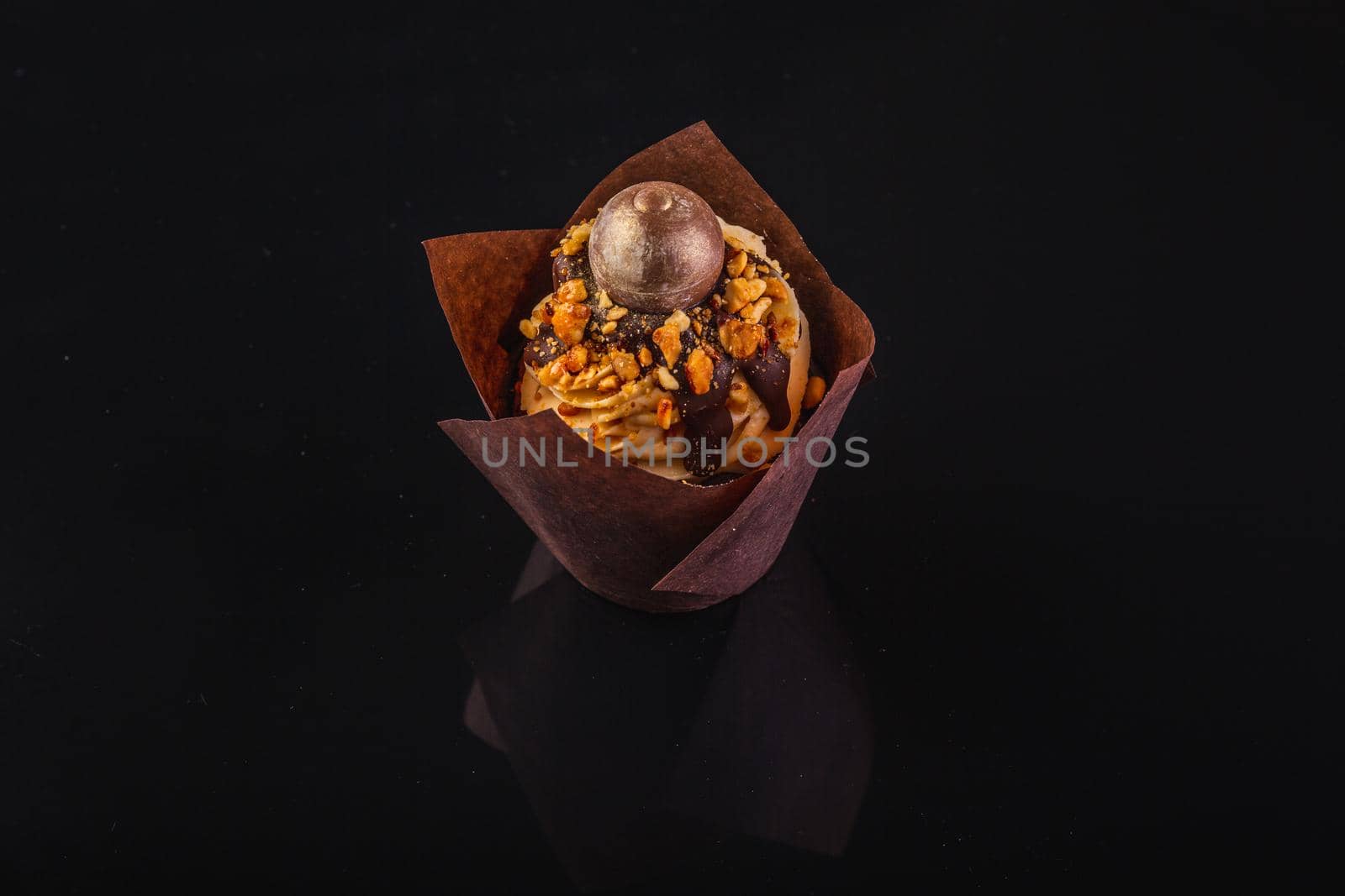 Peanut Butter Cupcake On A Black Background With Reflection.