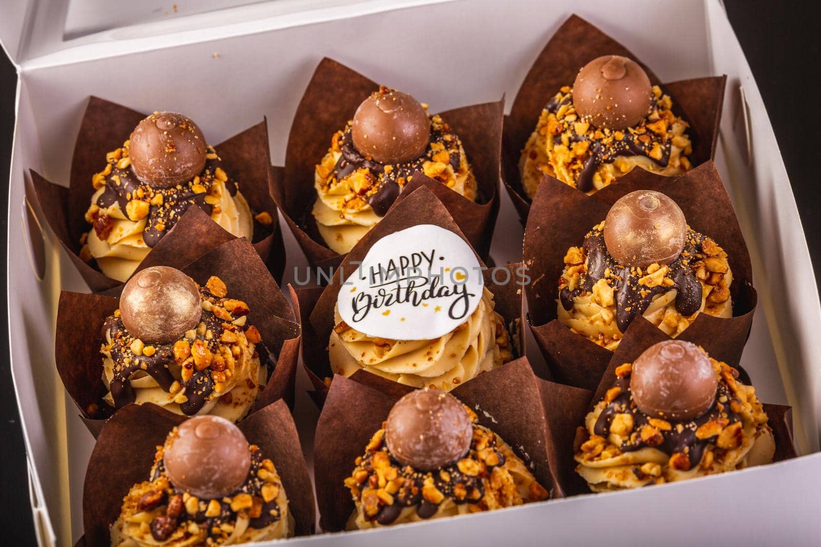 Box of Peanut Butter Cupcakes On A Black Background With Reflection.