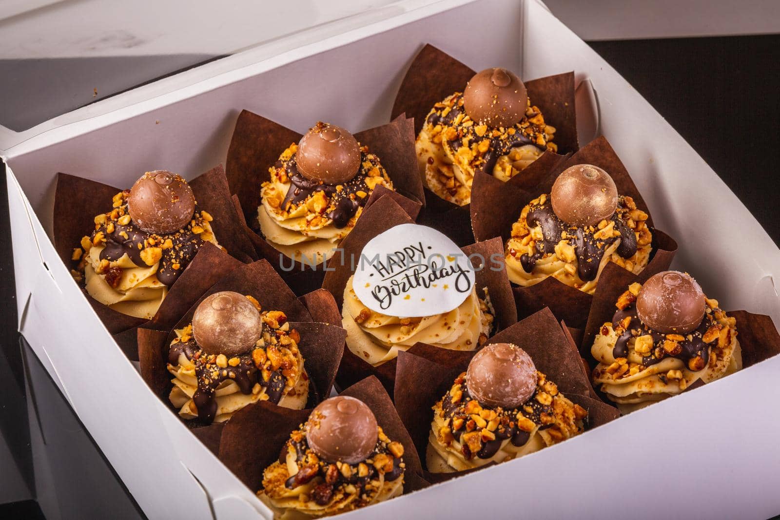 Box of Peanut Butter Cupcakes On A Black Background With Reflection.