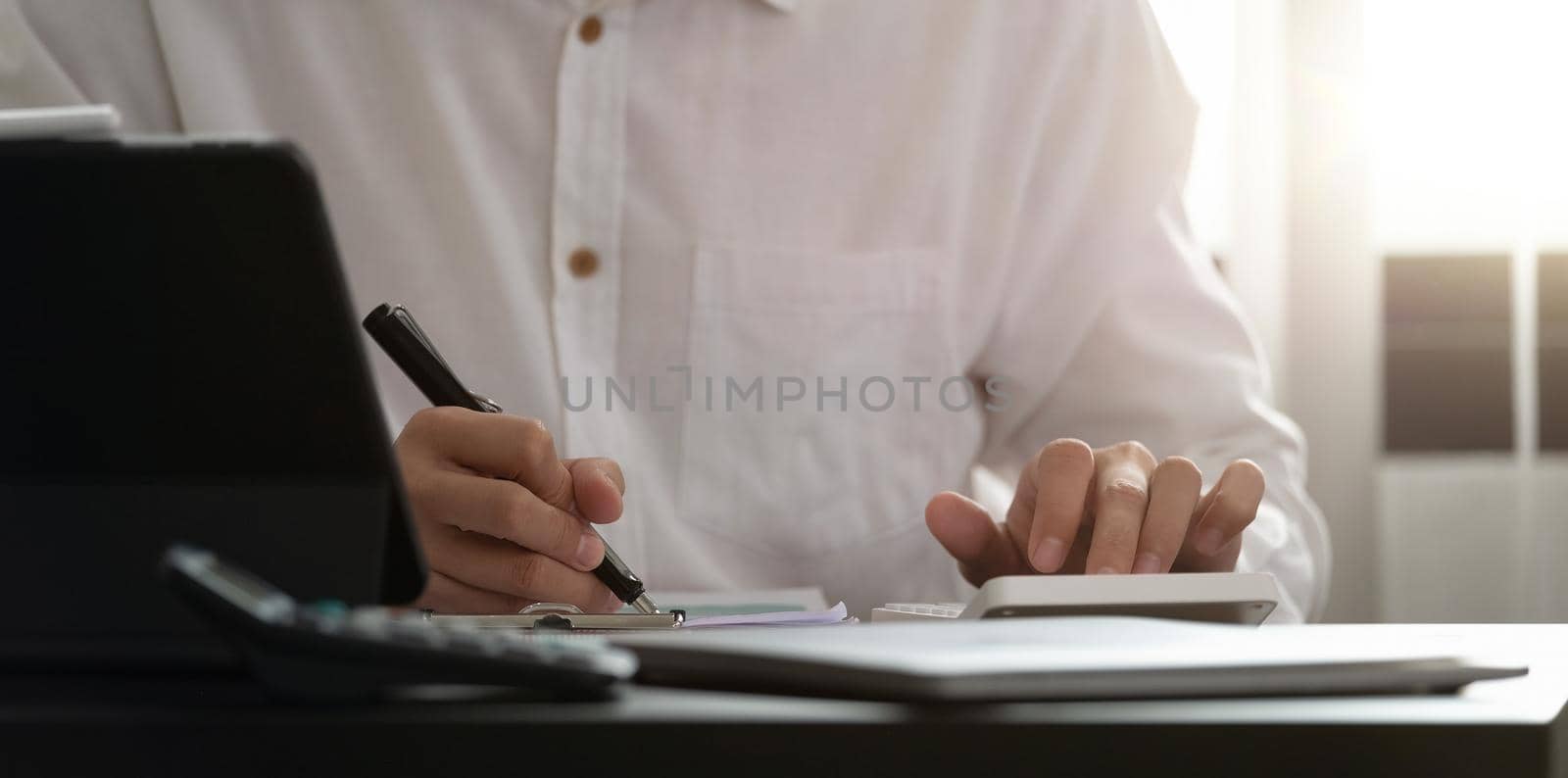 Close up of man using calculator. Serious office worker prepare financial report. Professional accountant