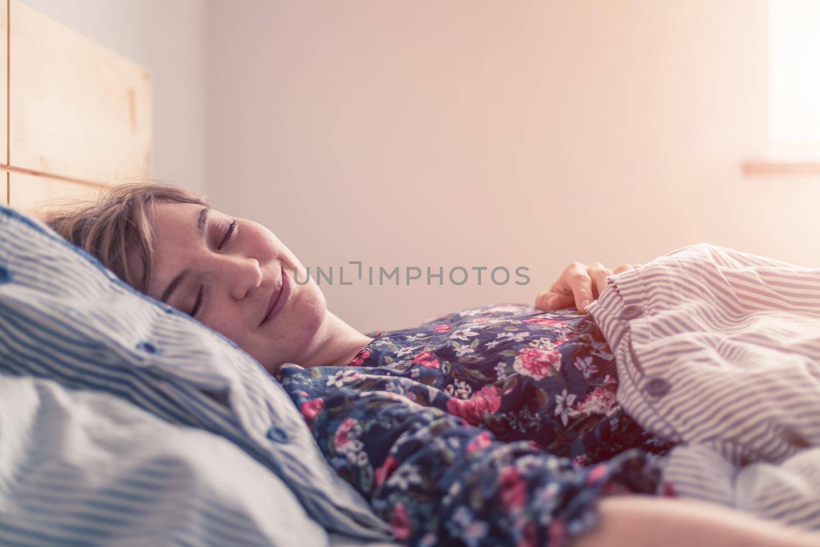 Restful sleep: Young female is sleeping in her bed, close up by Daxenbichler