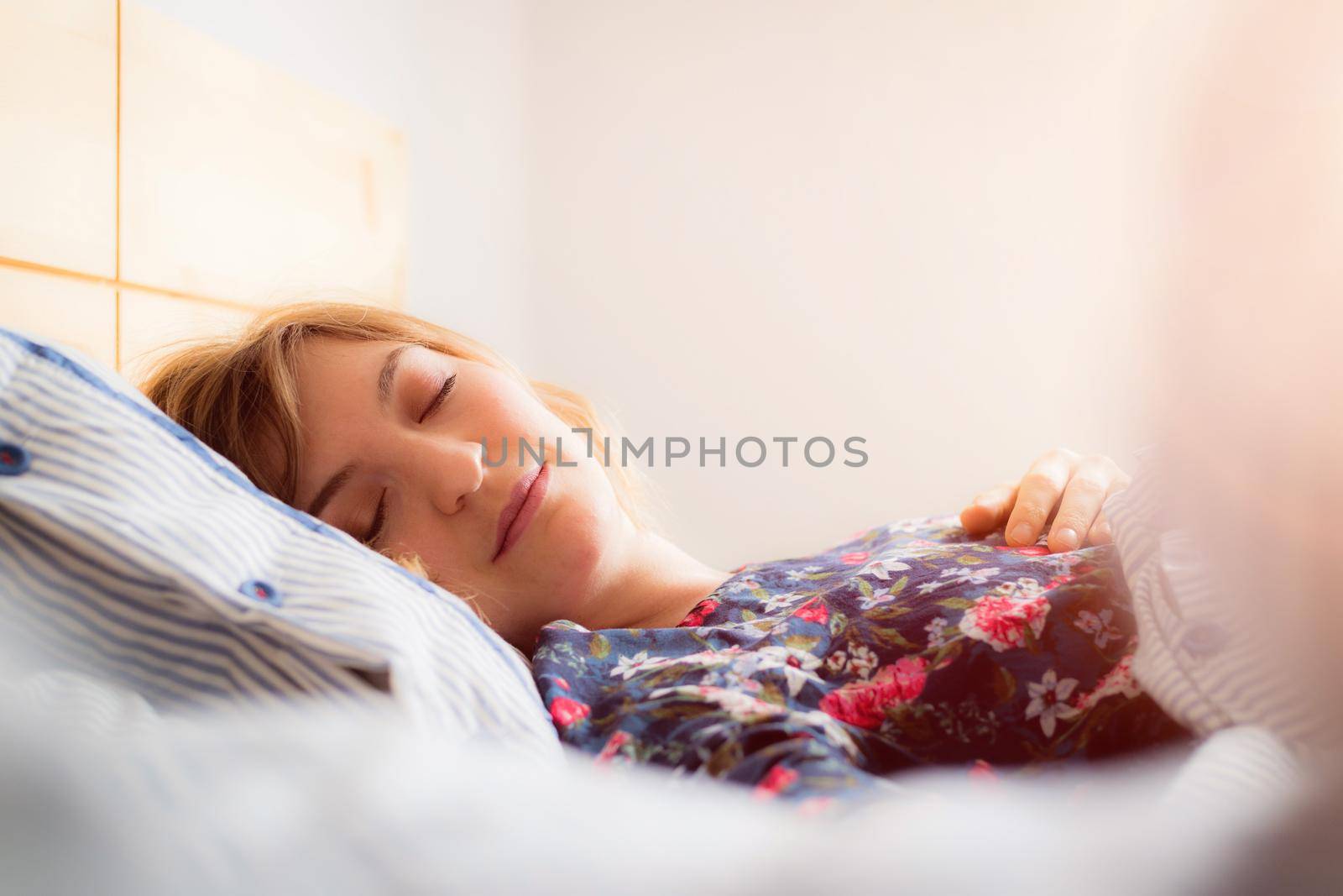 Restful sleep: Young female is sleeping in her bed, close up by Daxenbichler
