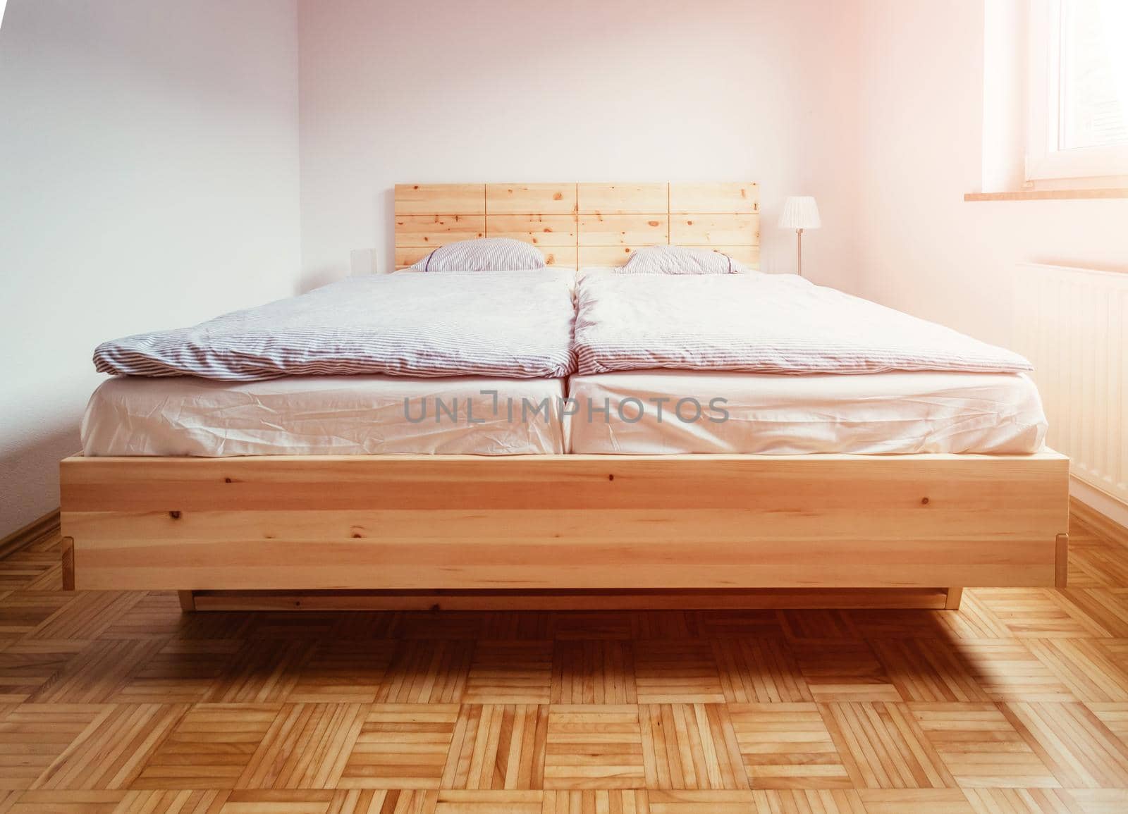 Stone pine bed: Empty wooden bed with pillow and blanket by Daxenbichler