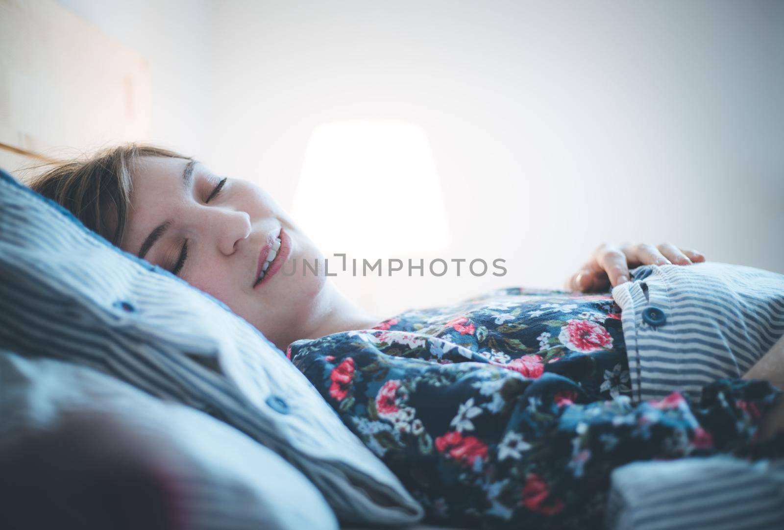 Young woman sleeping peacefully in her bedroom, day