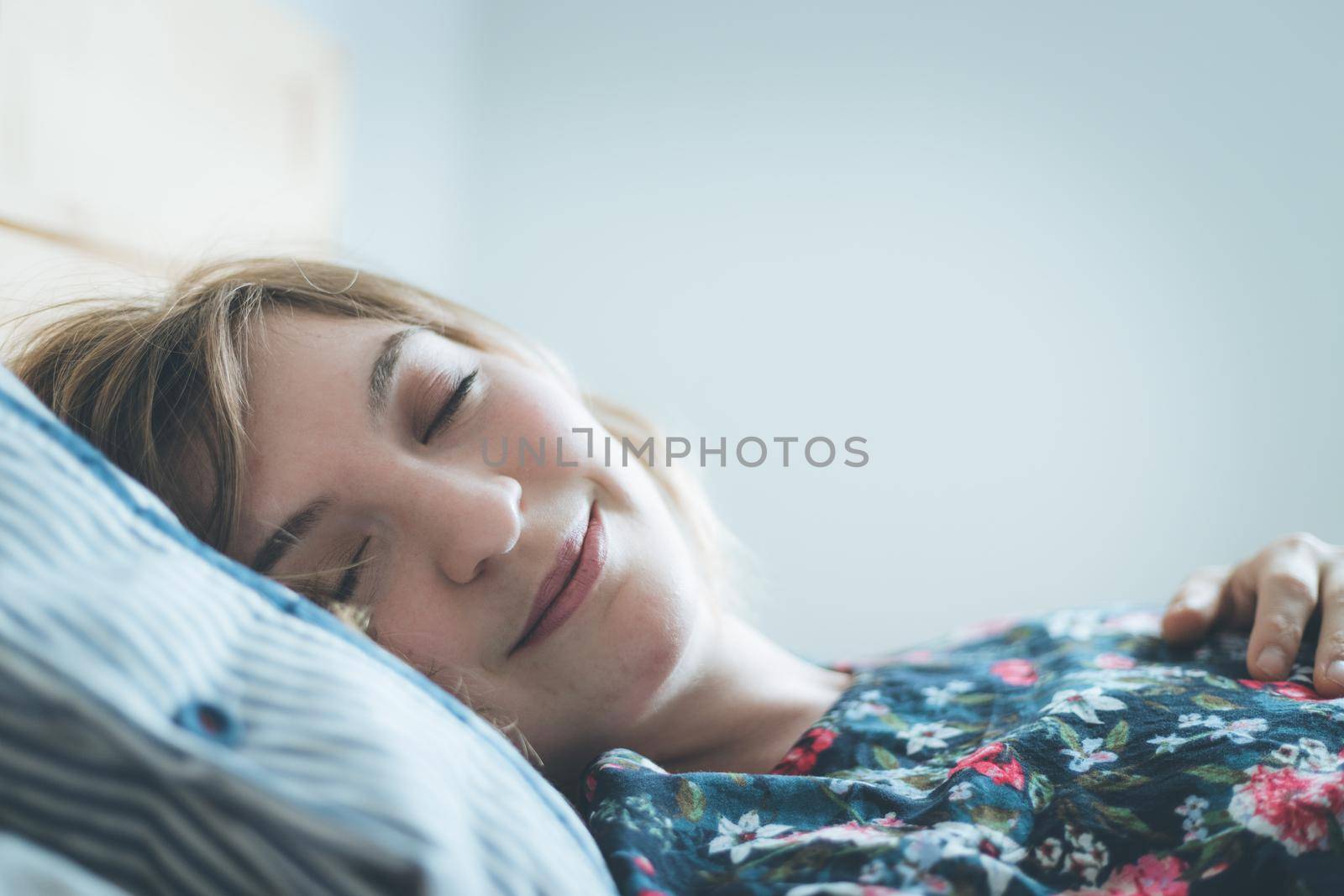 Young woman sleeping peacefully in her bedroom, day