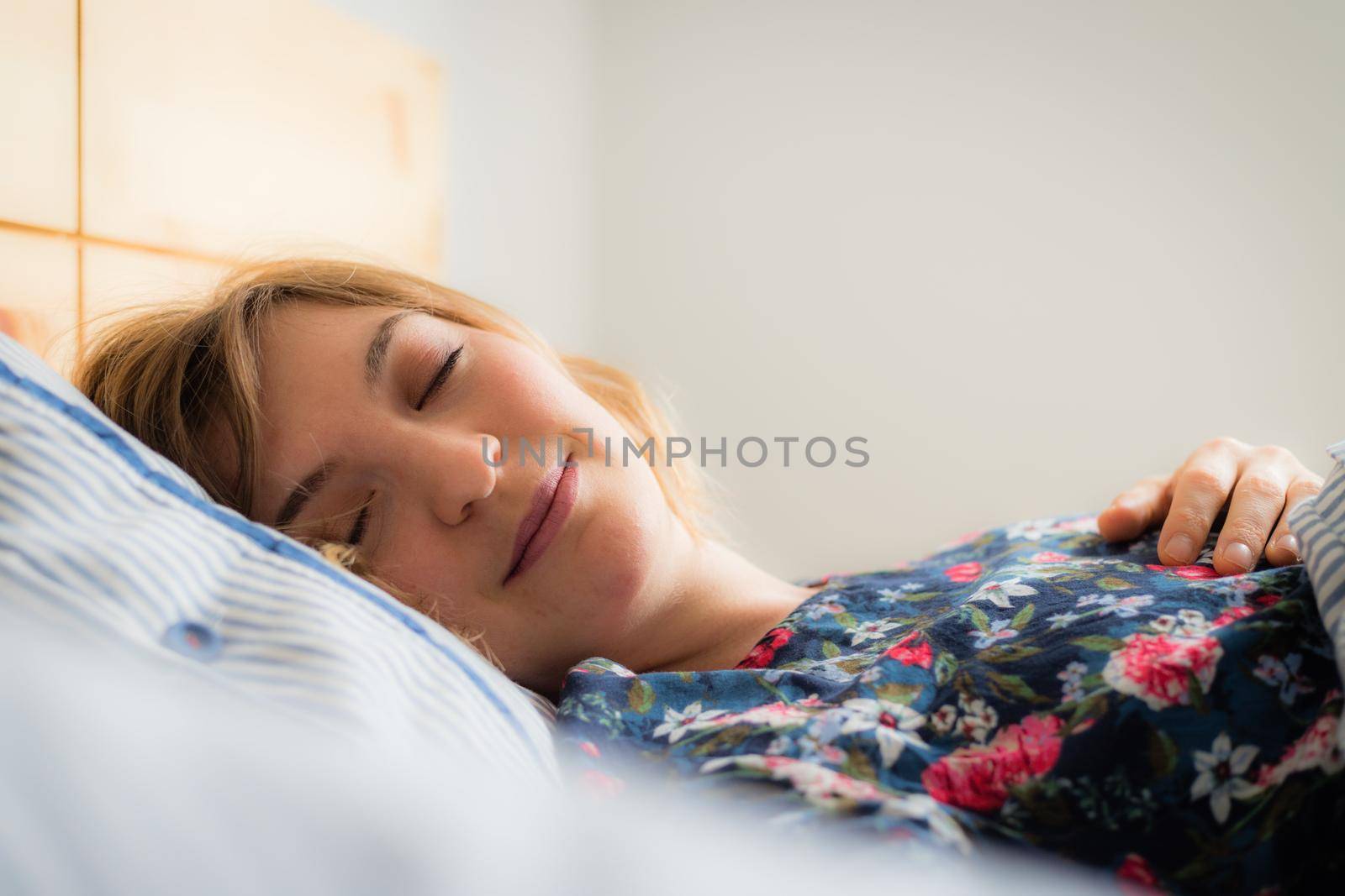 Young woman sleeping peacefully in her bedroom, day