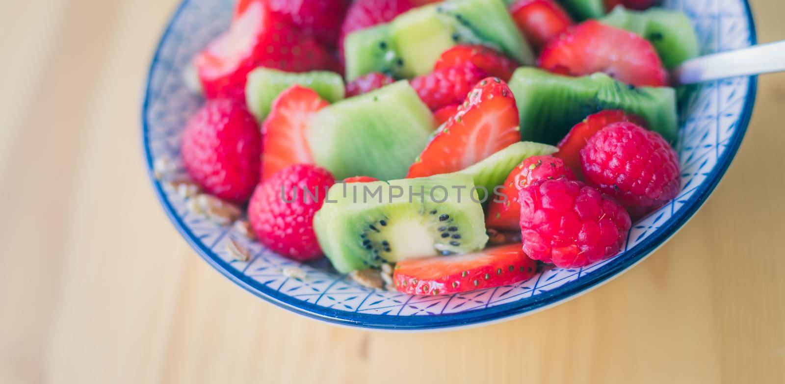 Close up of strawberries and kiwis in a ceramic bowl