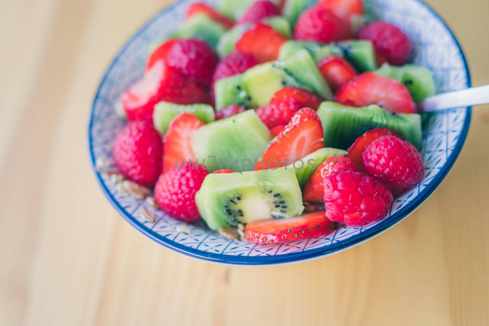 Breakfast fruit bowl with strawberries and kiwis, close up. Healthy lifestyle for vegetarians. by Daxenbichler