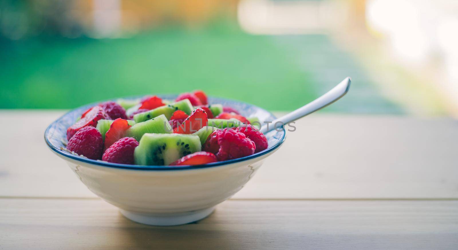 Close up of strawberries and kiwis in a ceramic bowl