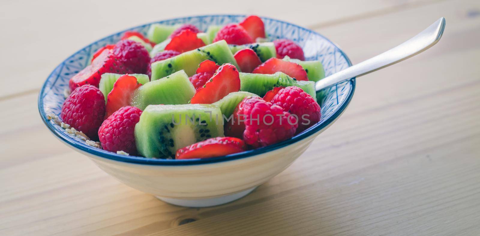 Close up of strawberries and kiwis in a ceramic bowl