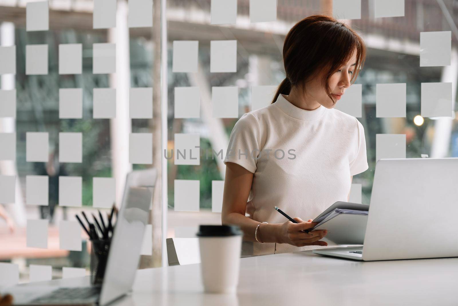 Businesswoman working with financial report and laptop computer at her office.