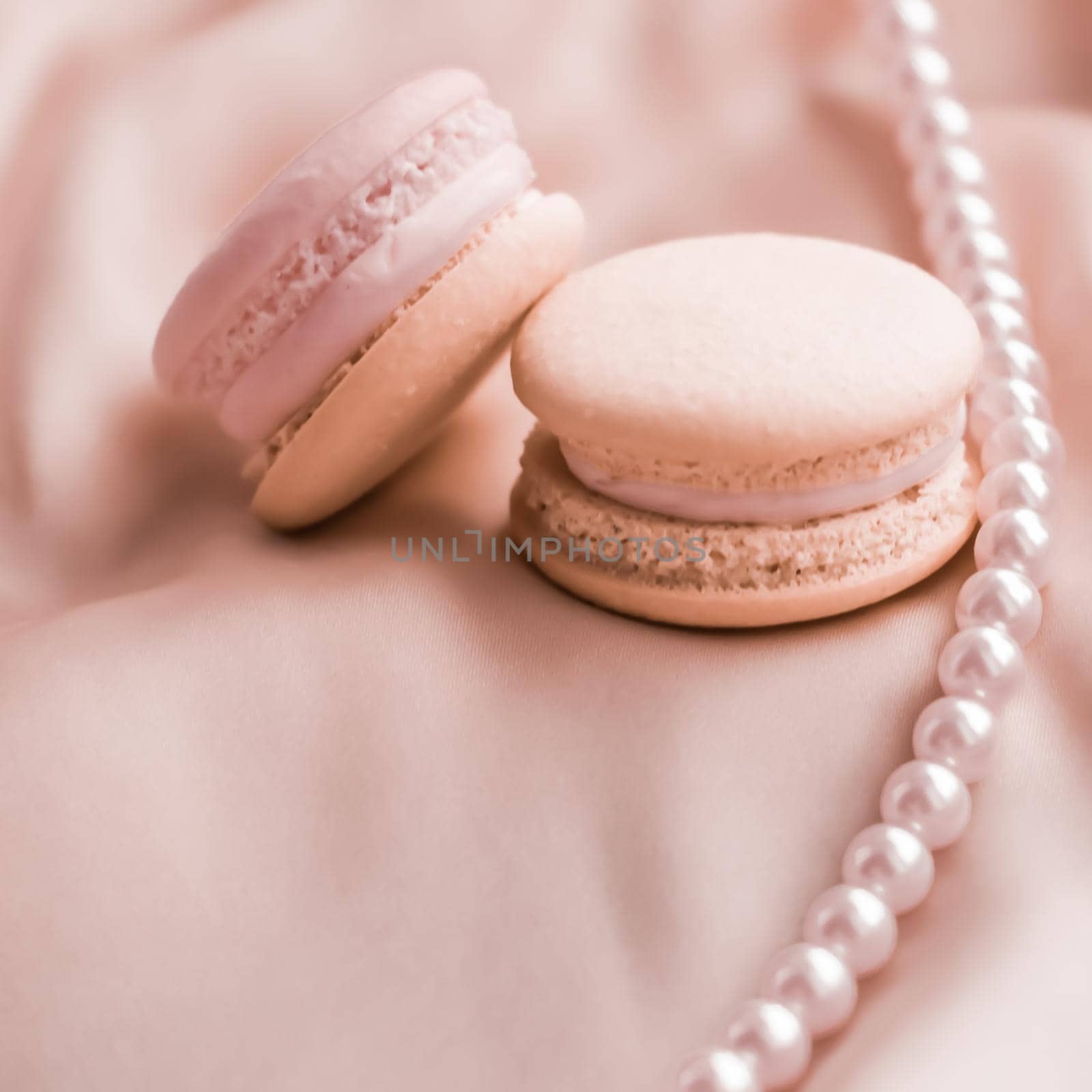 Sweet macaroons and pearls jewellery on silk background, parisian chic jewelry, French dessert food and cake macaron for luxury confectionery brand, holiday gift by Anneleven