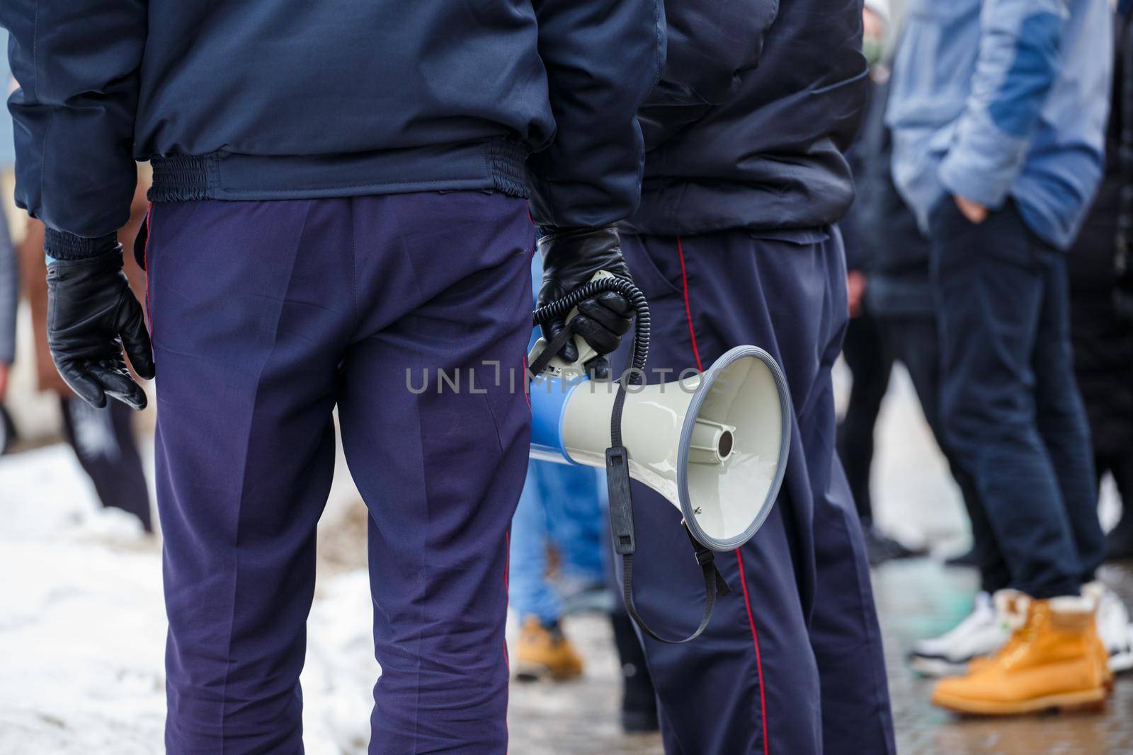 police officer holding loudspeaker megaphone at daylight, close-up with selective focus