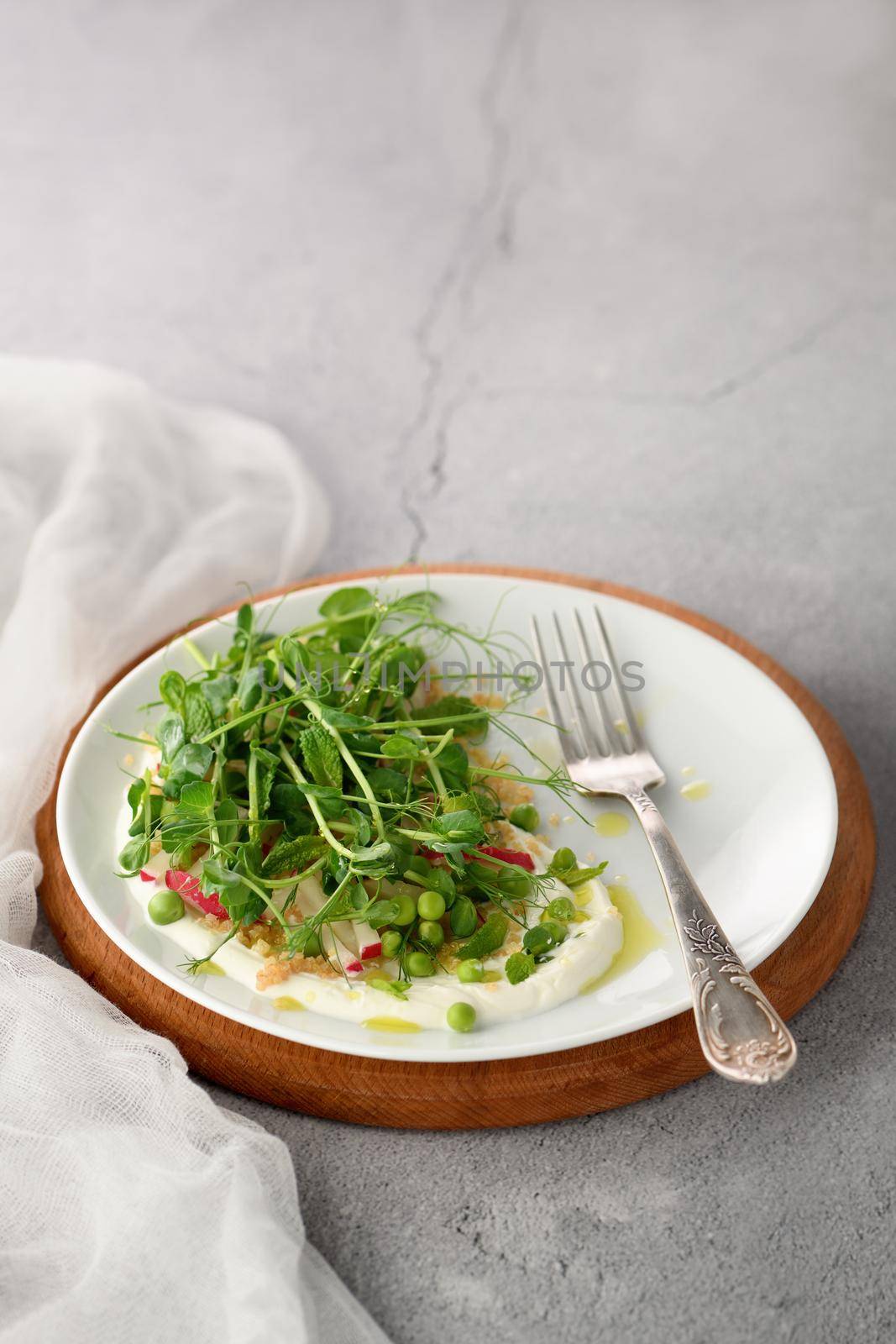 Vegan healthy salad made microgreen sprouts peas, quinoa, radish, mint and yogurt 
