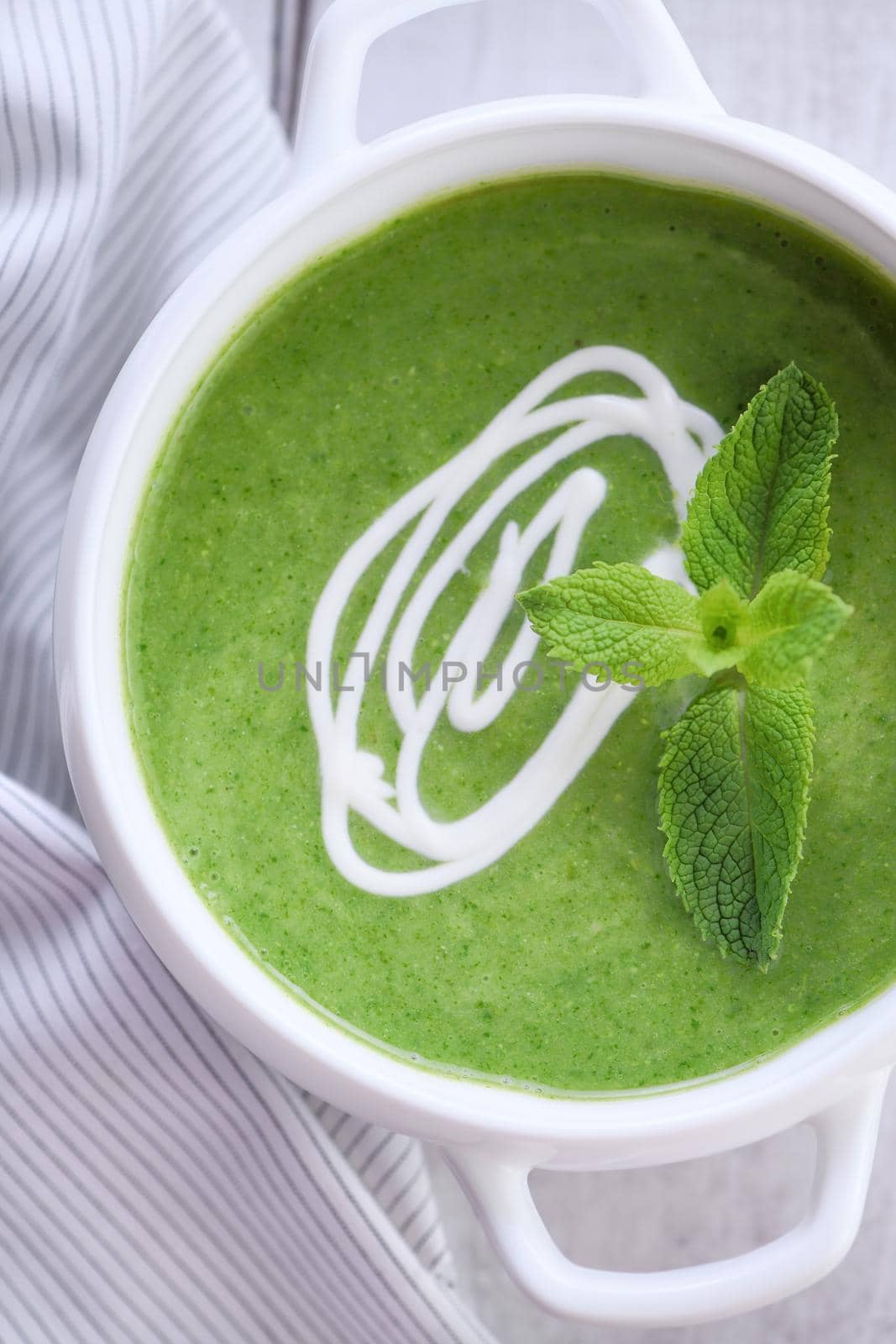 Spinach puree soup seasoned with cream and mint