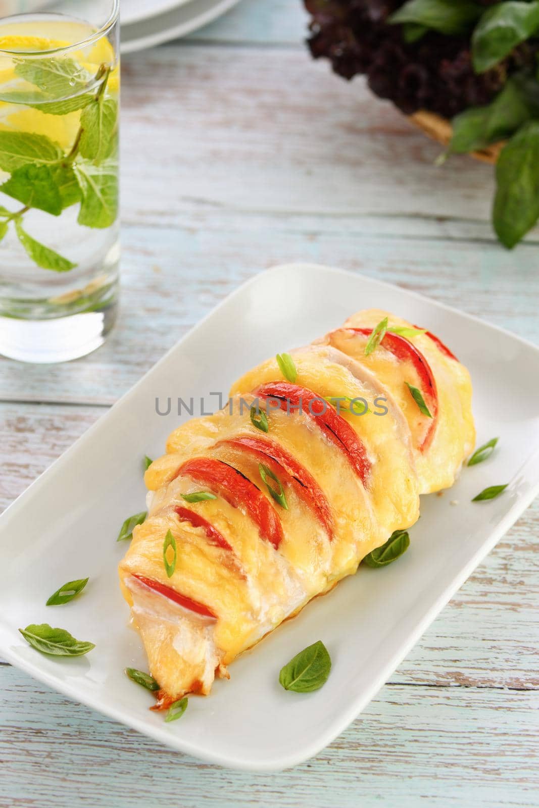 Chicken caprese. Tender chicken breast baked with slices of tomato and cheese.