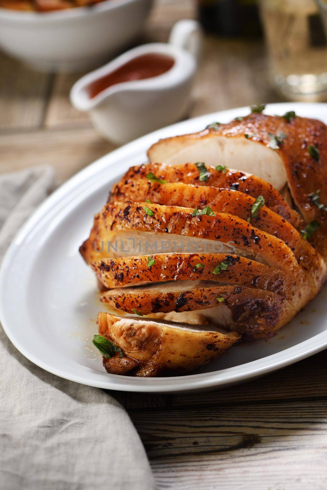 Sliced into slices baked turkey breast close-up at the dinner table