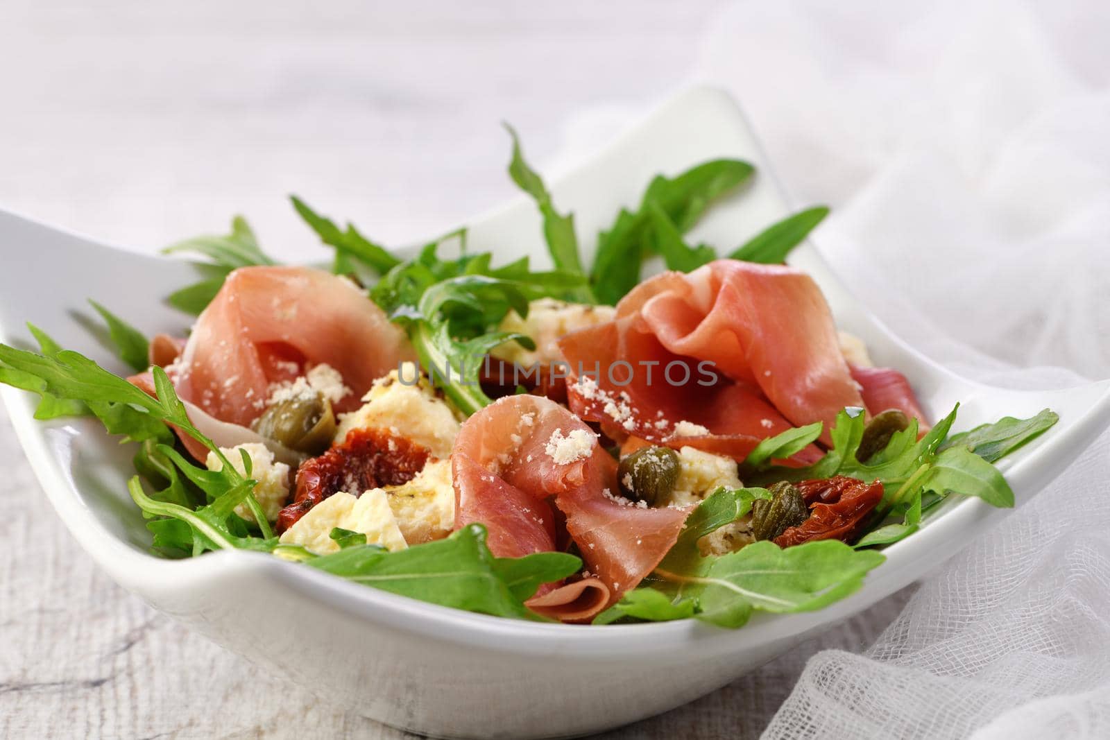 Arugula salad, prosciutto with sun-dried tomatoes by Apolonia