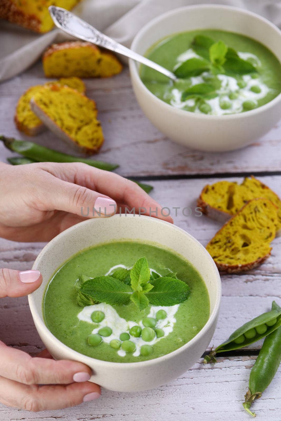 Chilled soup puree of green peas,  seasoned with green onion, mint and crunchy  toasted diced rusk bread  