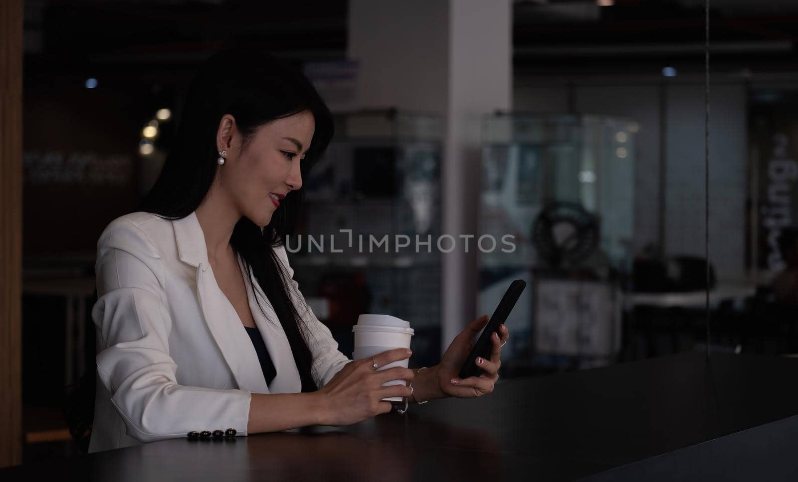 Shot of businesswoman using smartphone for video calling during working from home. by nateemee