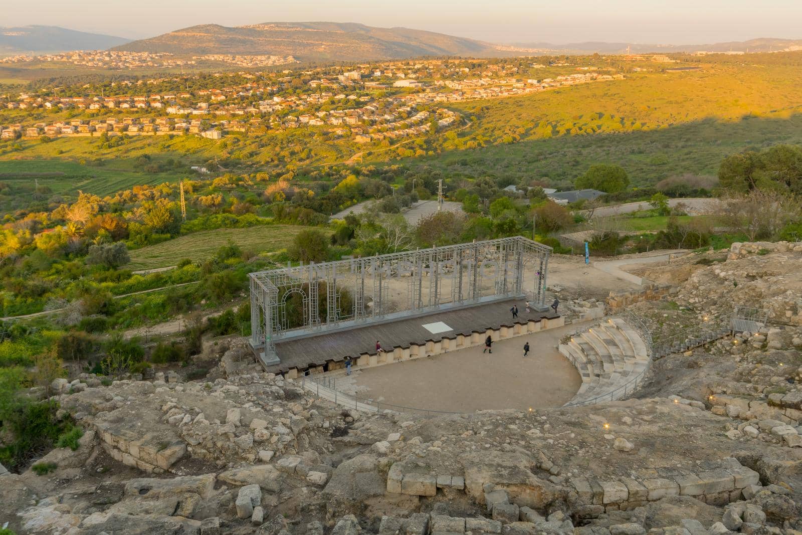 Tzipori, Israel - March 29, 2021: Sunset view of the ancient Roman Theater, with visitors, landscape and countryside, in Tzipori National Park, Northern Israel