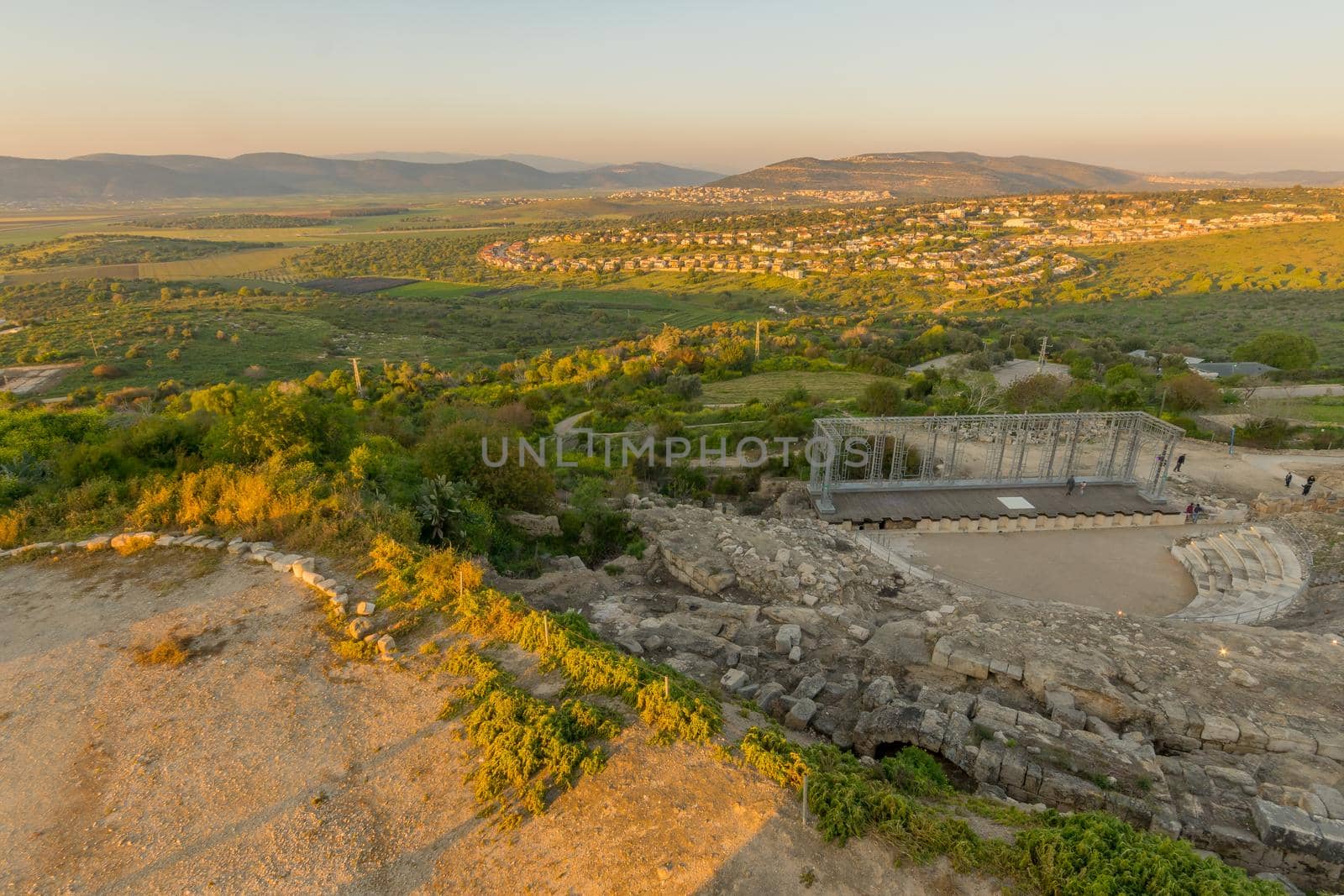 Tzipori, Israel - March 29, 2021: Sunset view of the ancient Roman Theater, with visitors, landscape and countryside, in Tzipori National Park, Northern Israel