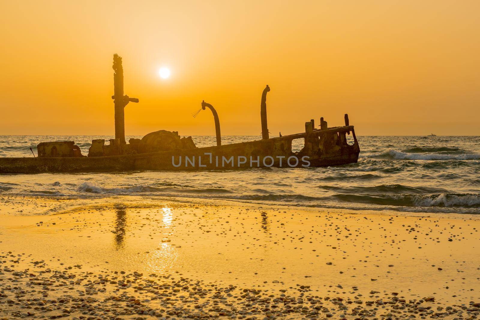 Sunset view of a rusty shipwreck in HaBonim Beach by RnDmS