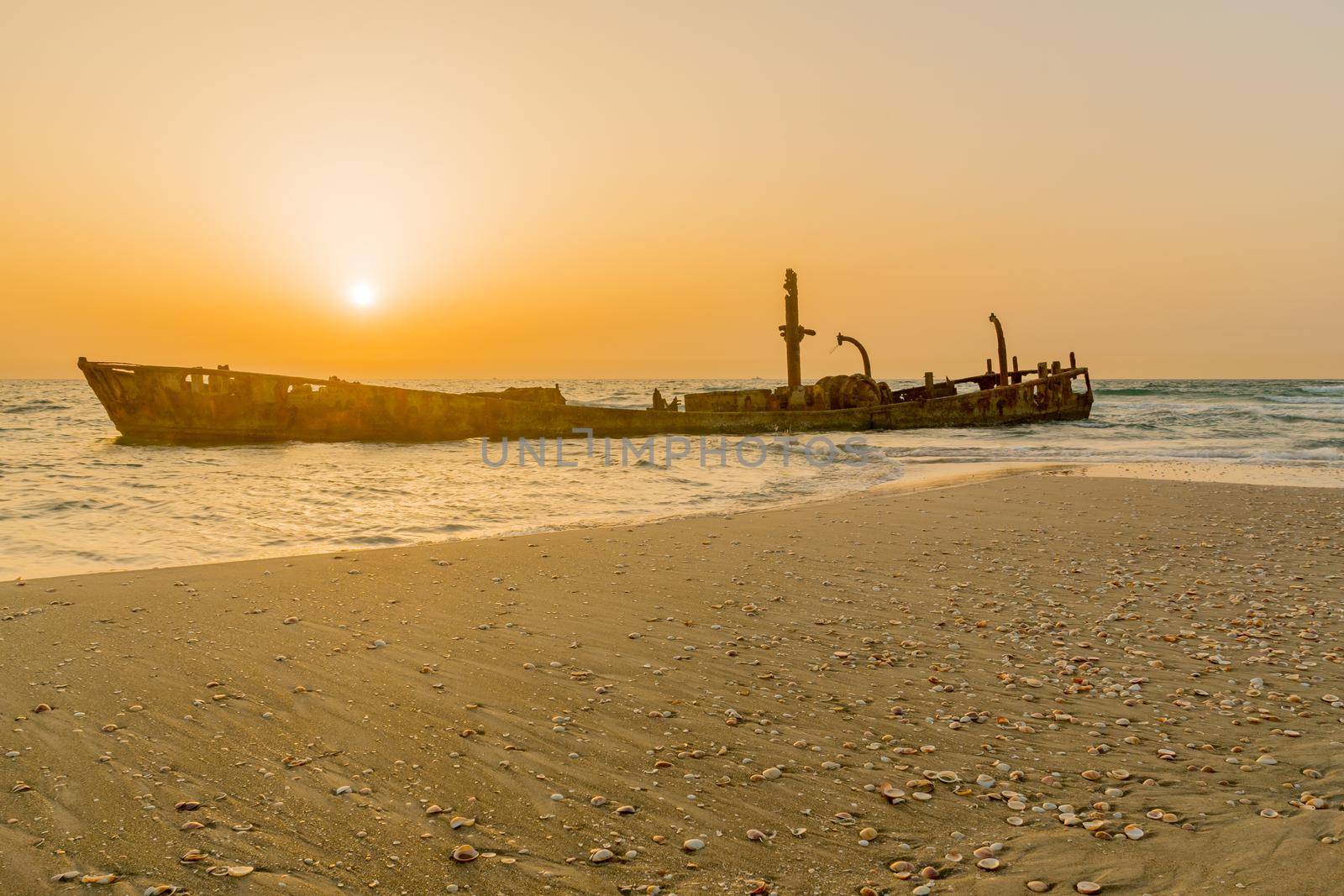 Sunset view of a rusty shipwreck in HaBonim Beach by RnDmS