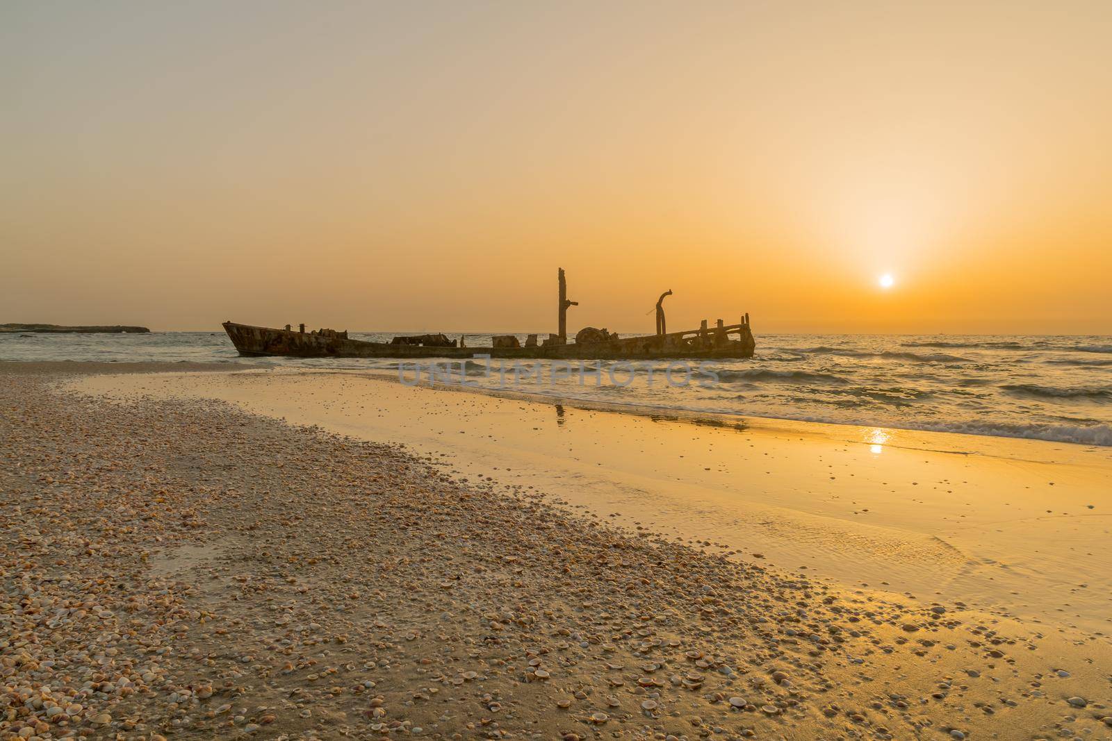 Sunset view of a rusty shipwreck in HaBonim Beach, Northern Israel