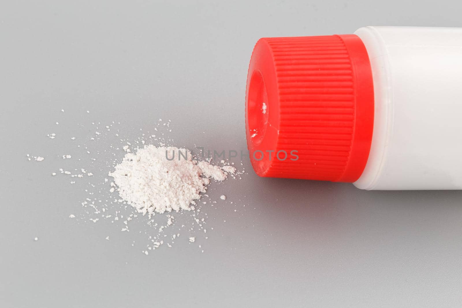 white plastic bottle of baby powder on gray background.