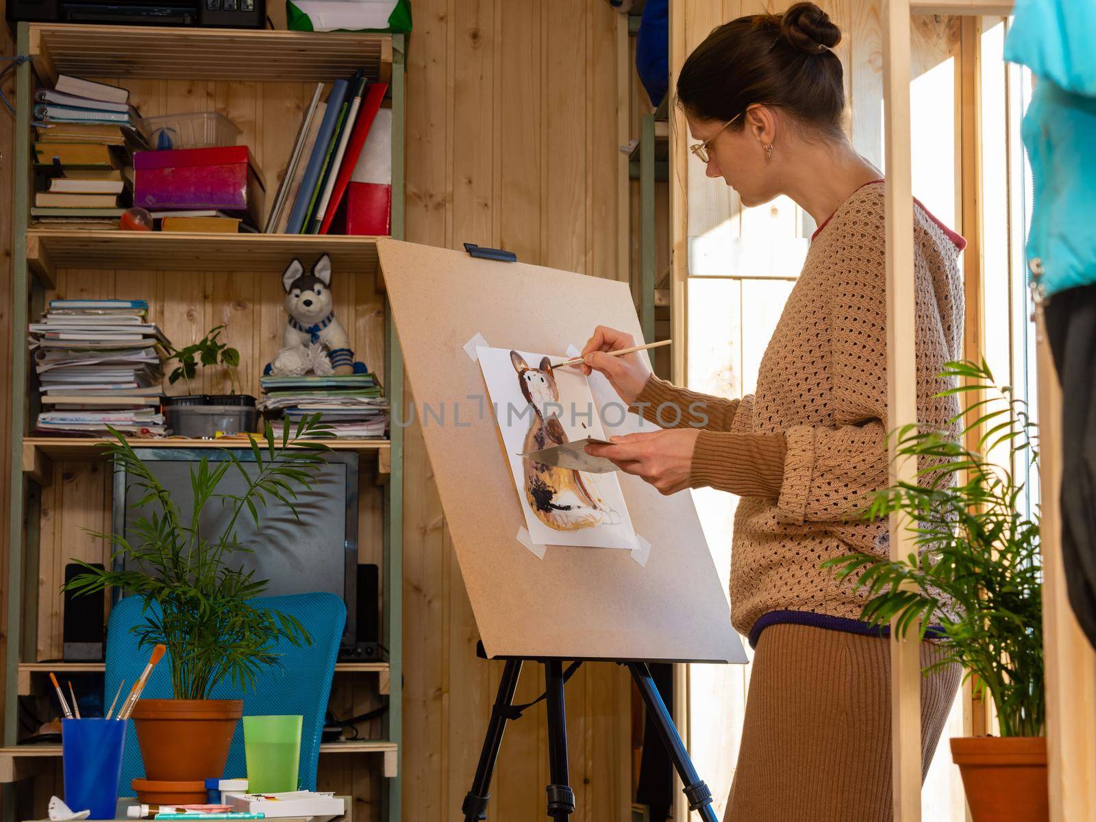 Girl artist draws on an easel at home