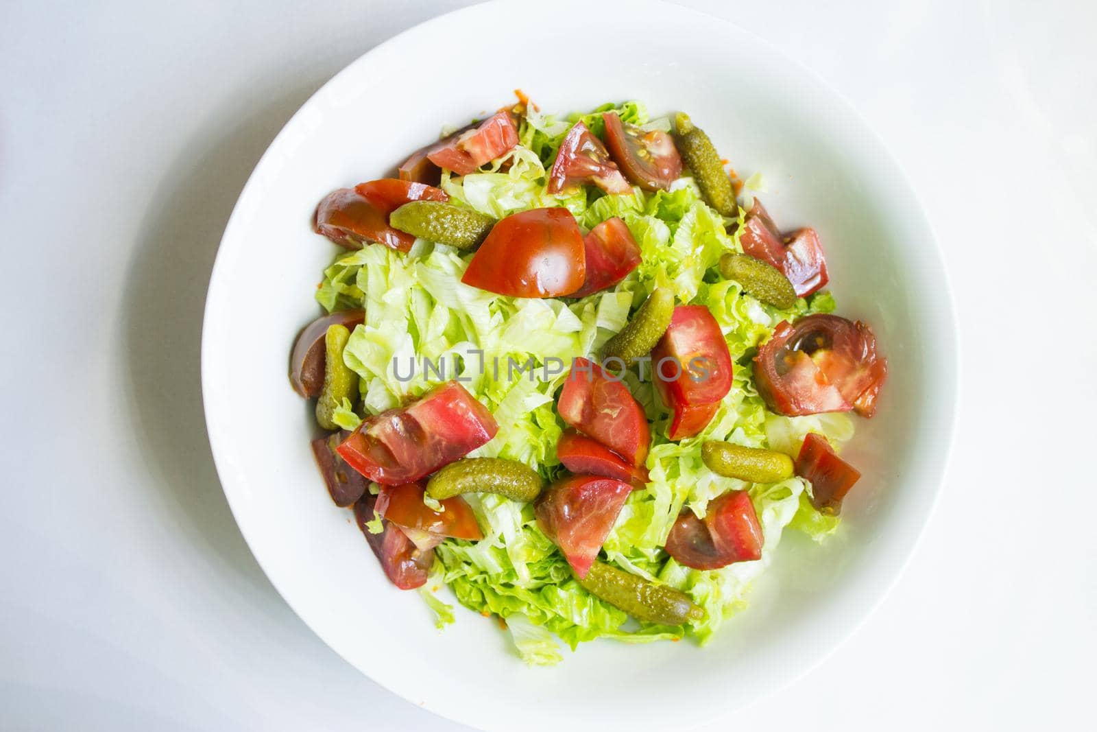 Lettuce salad with tomato and pickles. Raw food