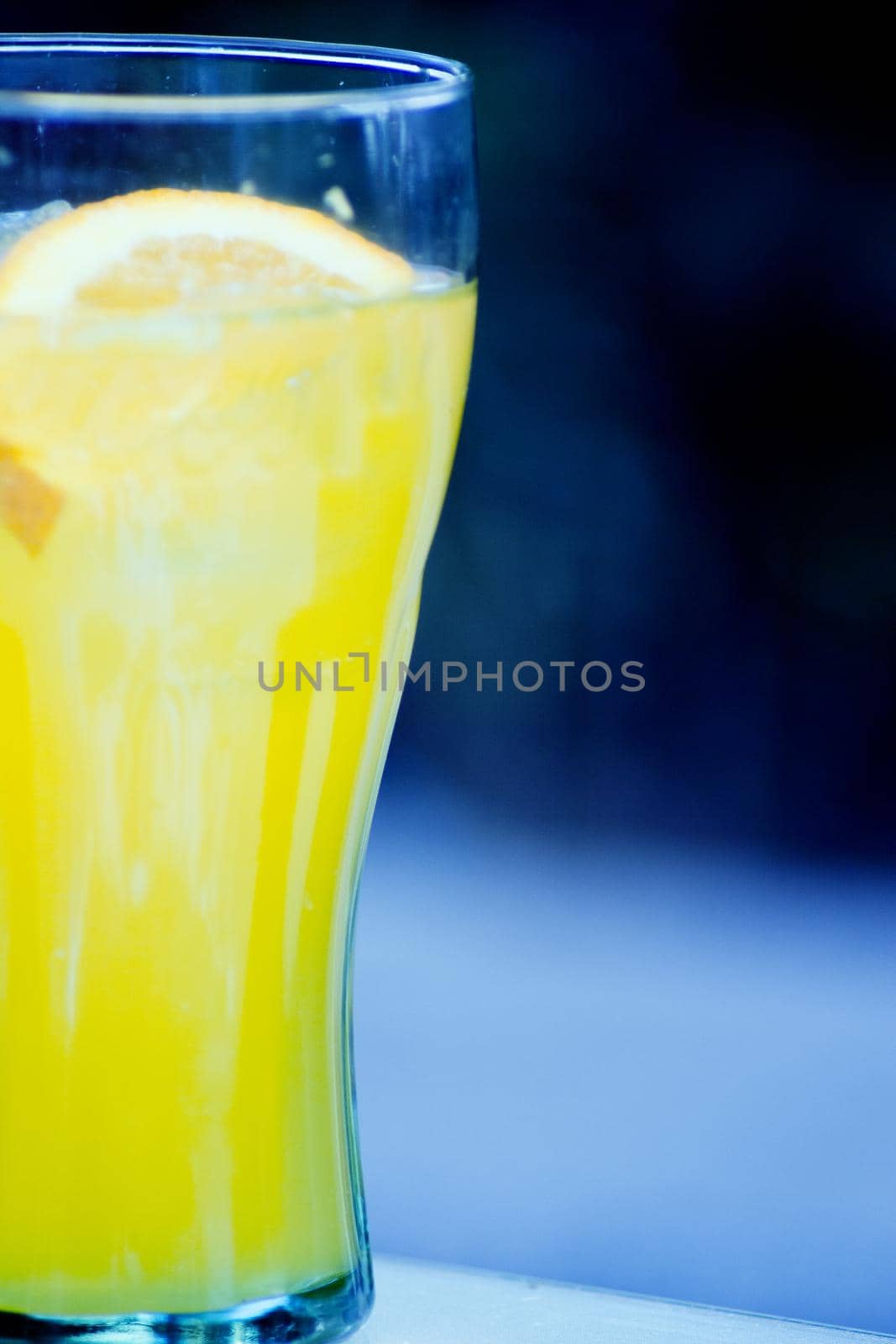 Orange soda in a crystal glass with a piece of natural orange. No people