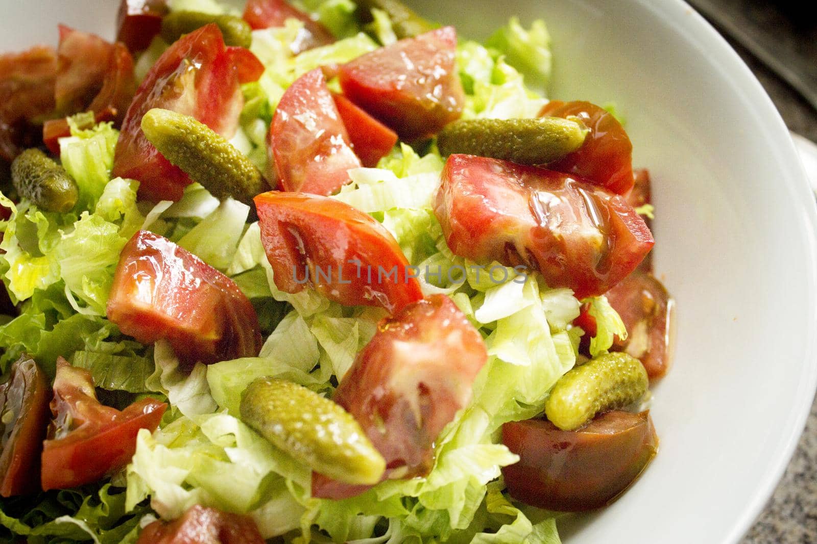 Lettuce salad with tomato and pickles. Raw food