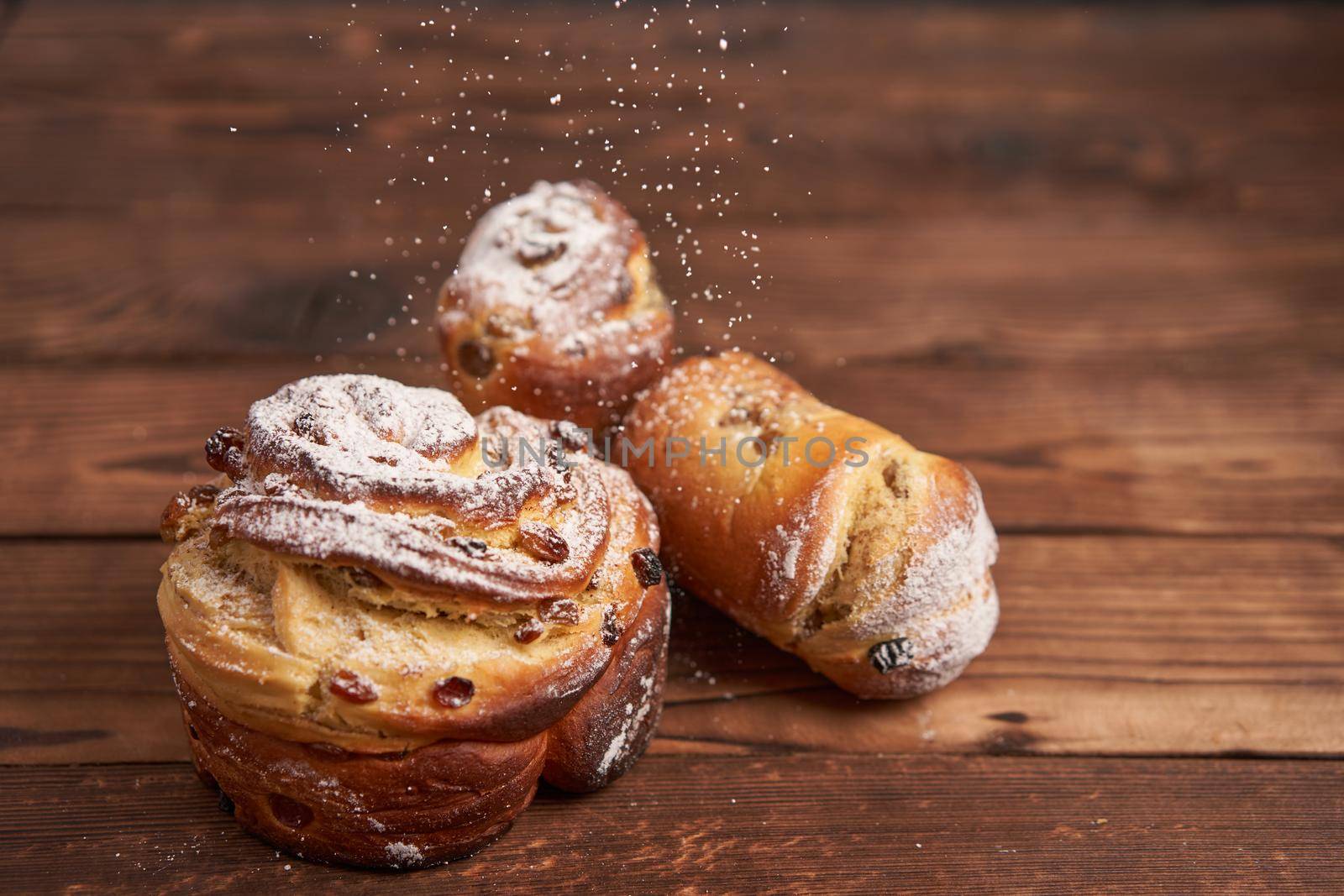 Traditional easter cake Kraffin stands on wooden table against a dark background. Spring holiday bread with copy space