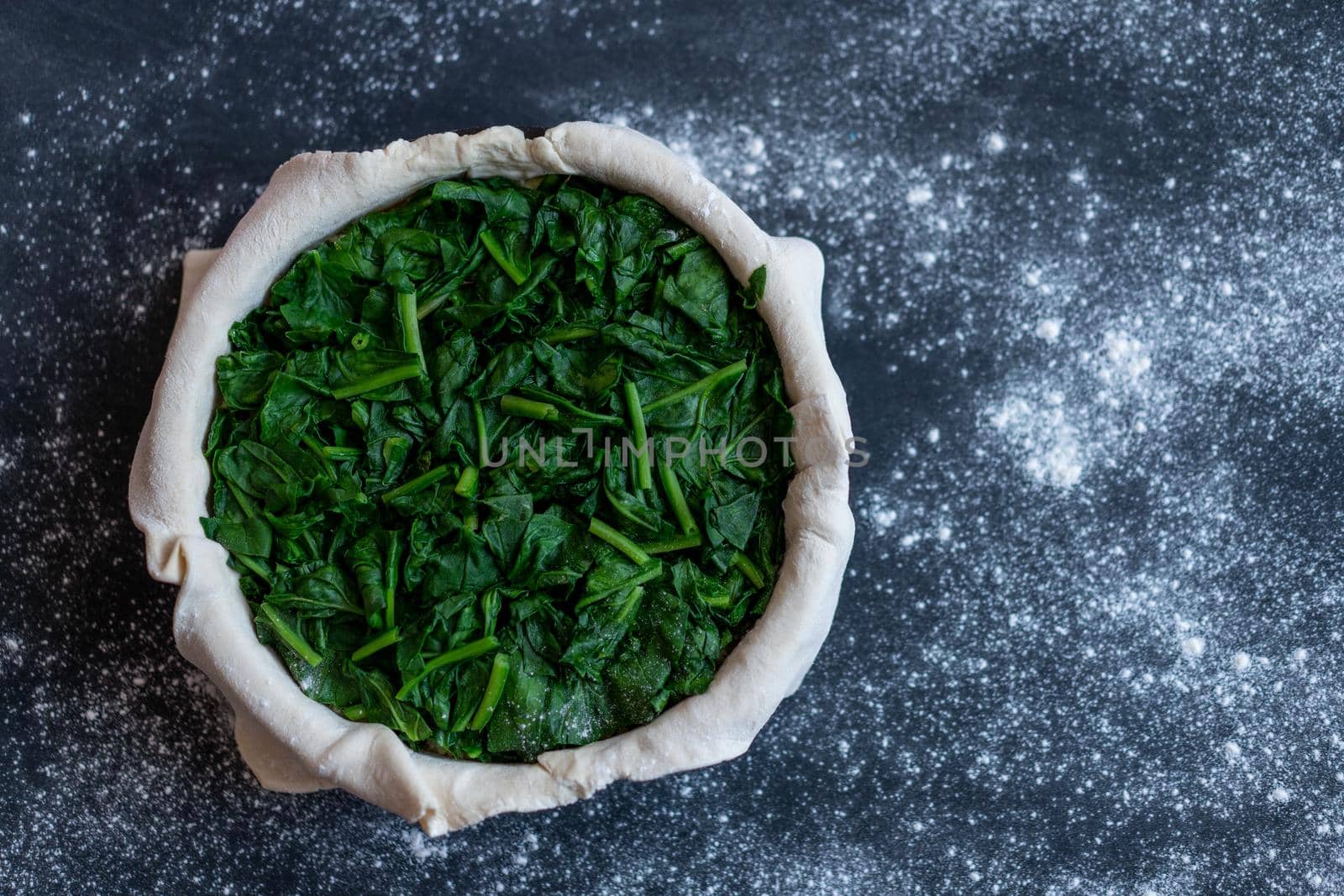 raw spinach pie preparation Standing wooden table background Copy space for text