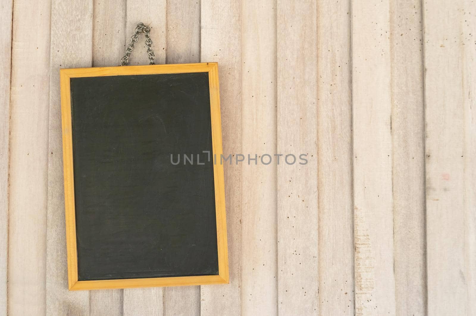 Blank copyspace black board on wooden wall background.