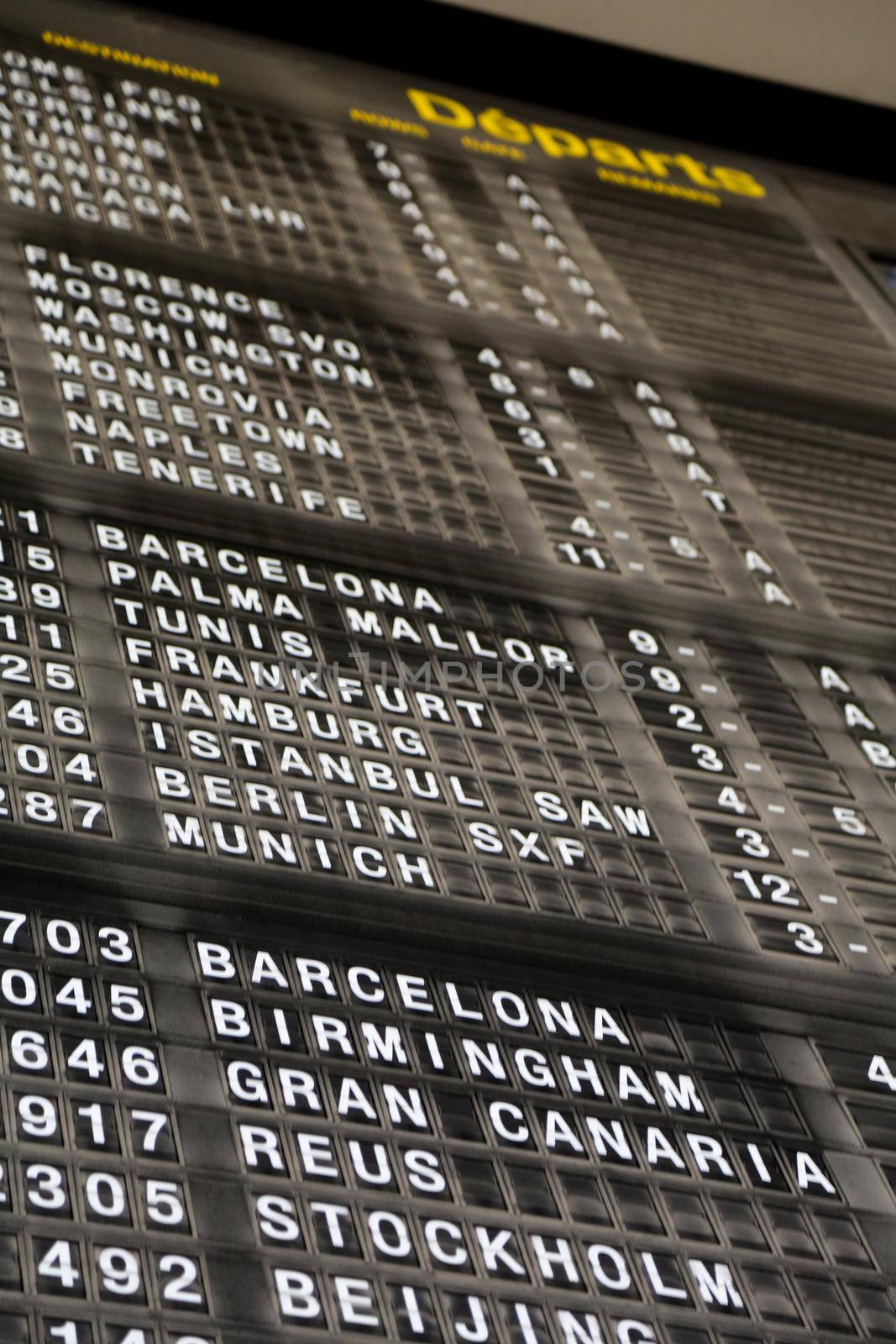 Airport departure board in terminal with flight information