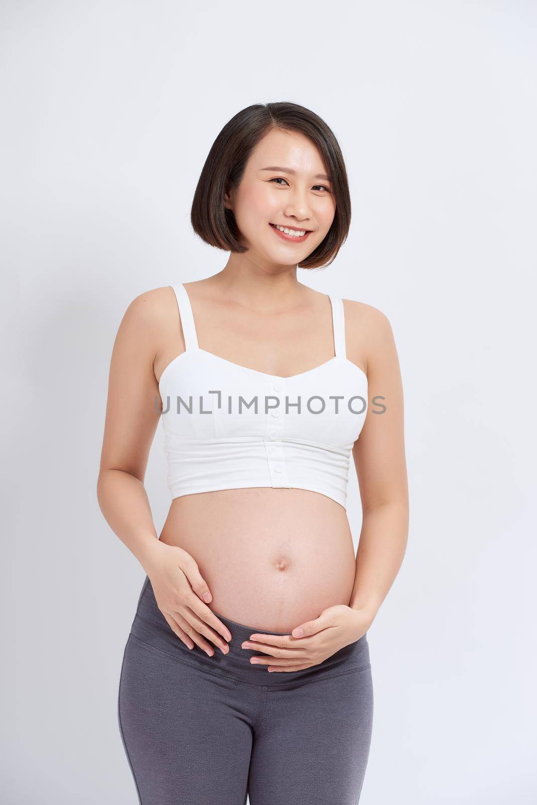 Beautiful asian pregnant woman expecting baby and touching her belly by makidotvn