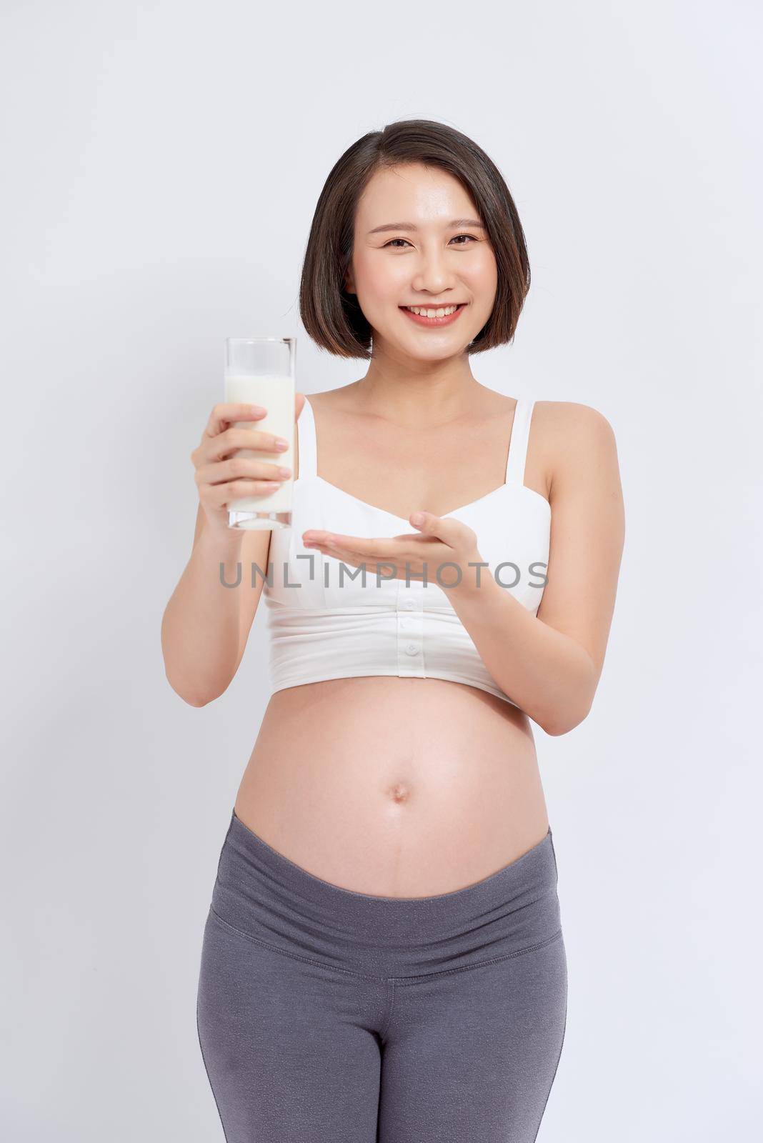 pregnant girl drinks milk on a white background by makidotvn