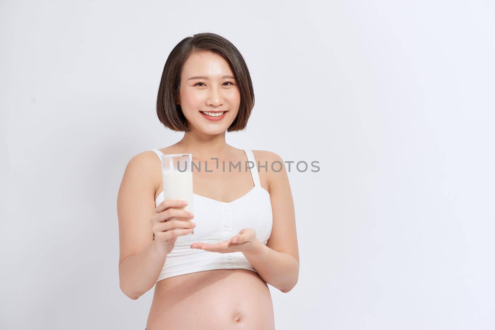 Pregnant woman drinking milk over white