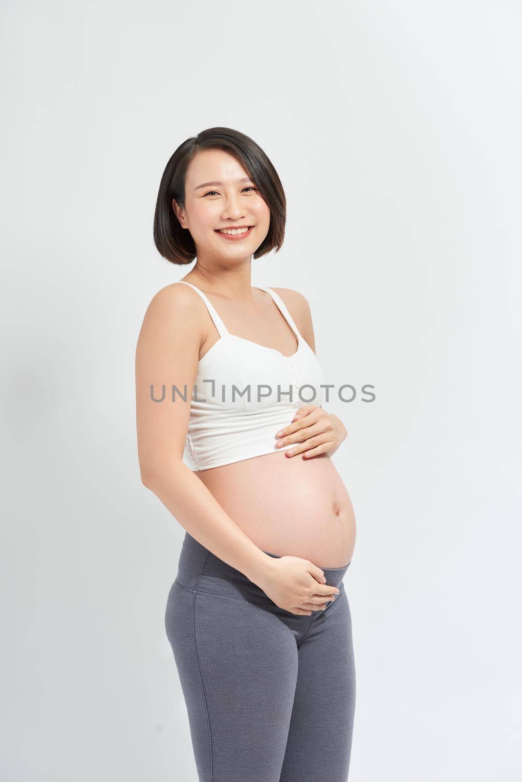 Pregnant woman feeling happy at home while taking care of her child.