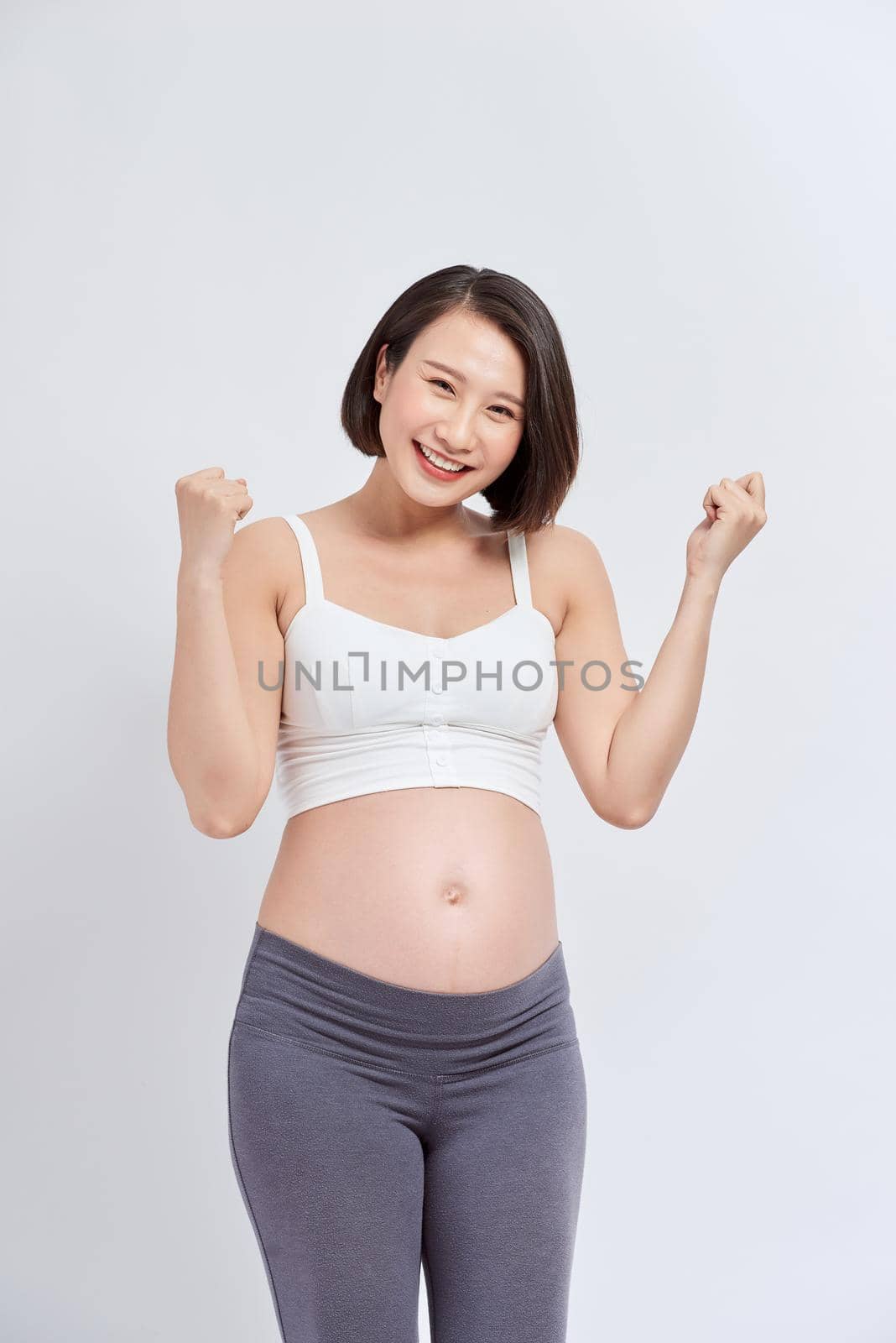 Happy pregnant woman with hands up, isolated on white