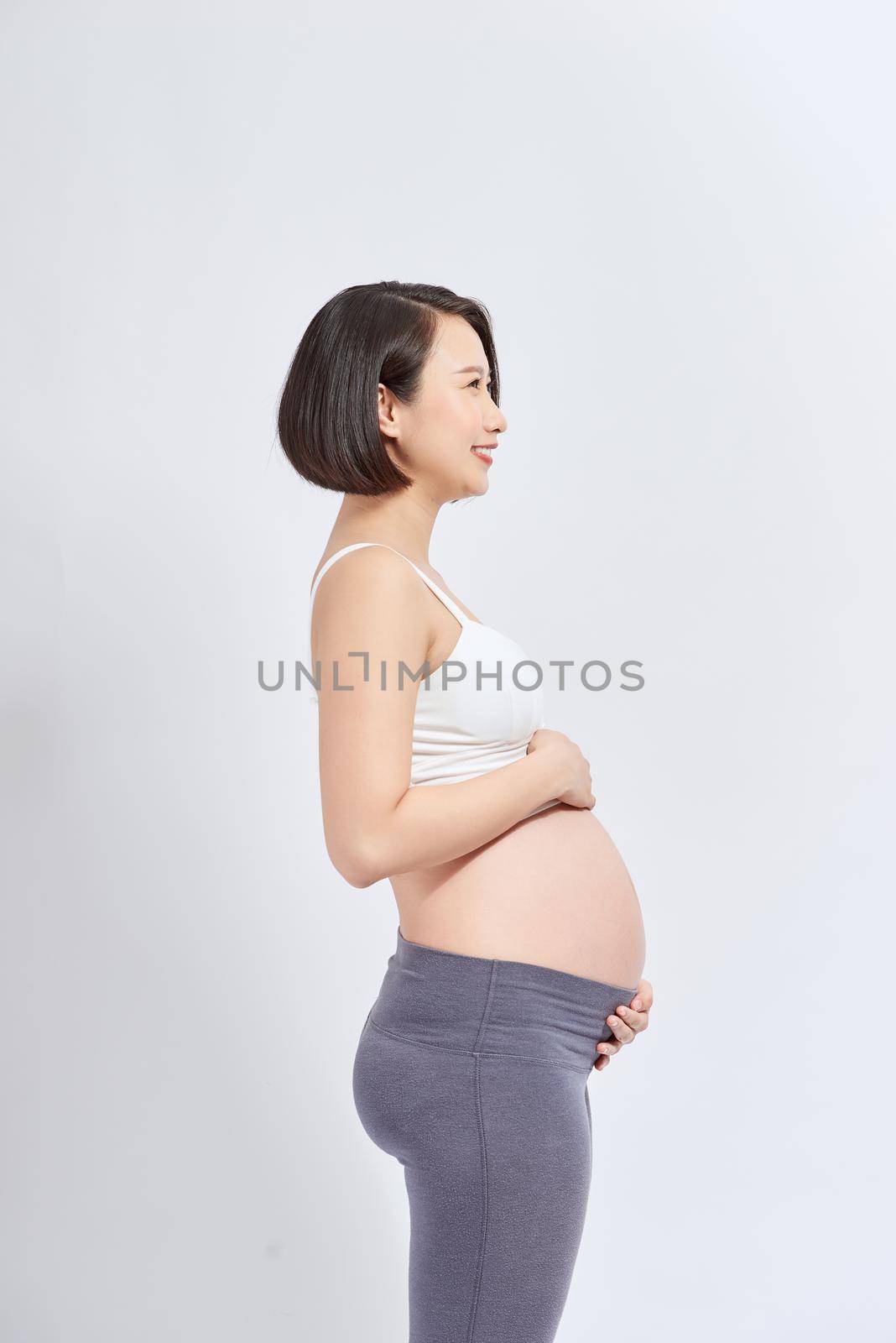 Pregnant woman feeling happy at home while taking care of her child.