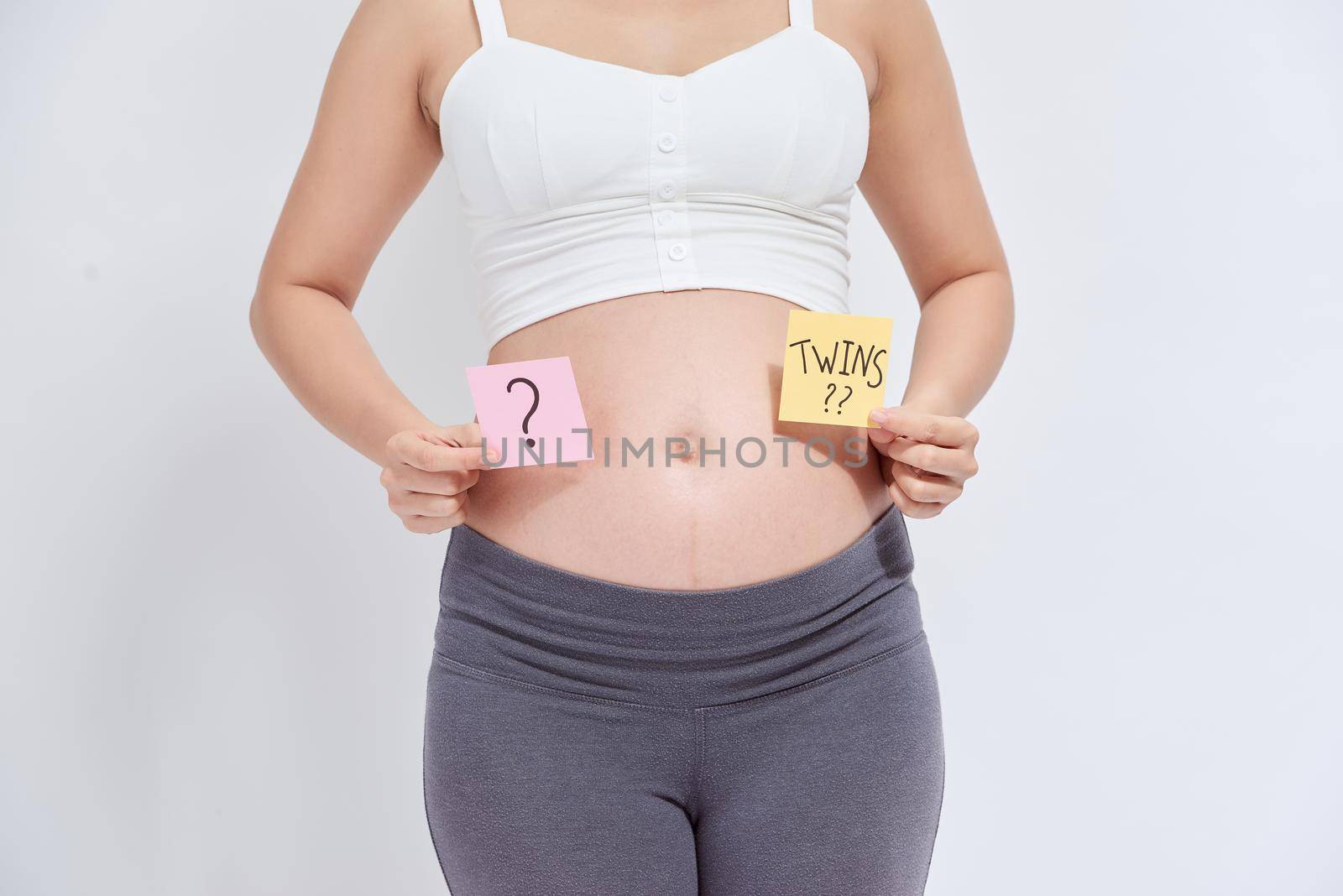 Asian pregnant woman with sticky note on her belly