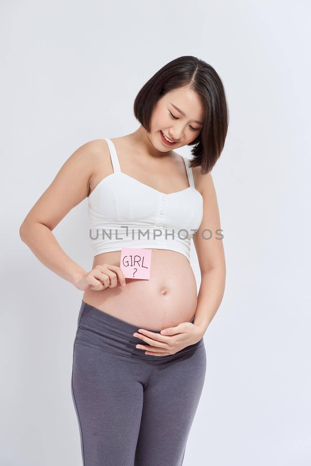 Pregnant woman with a sticky note saying Girl on her belly. Isolated on white background. by makidotvn